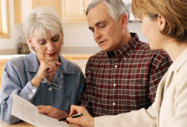An elder care professional counsels a senior couple